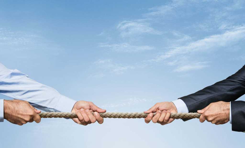 Tug war, two businessman pulling a rope in opposite directions isolated on white background